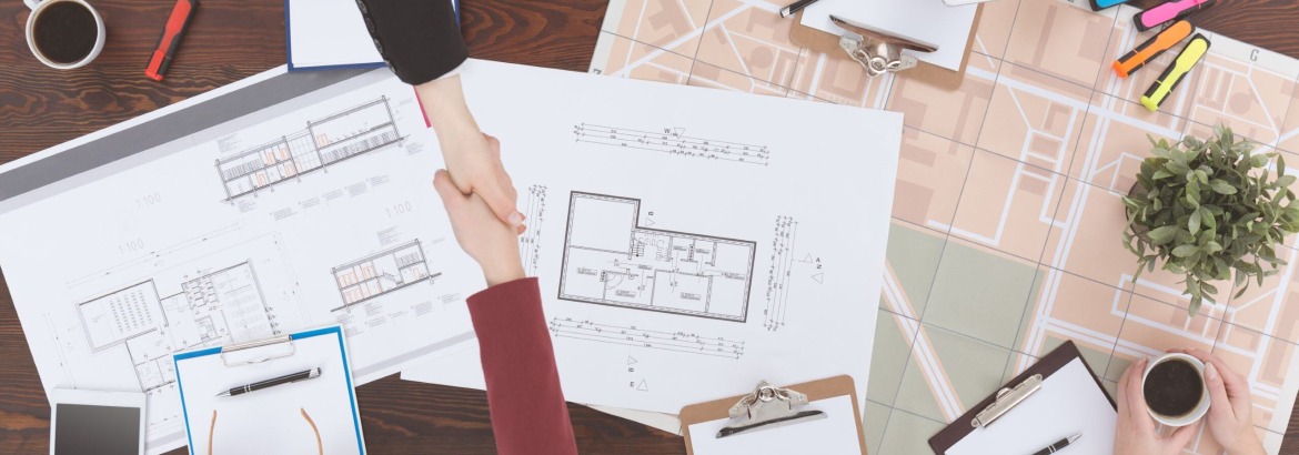 Overview point of view of people shaking hands with clipboards and drawings on table