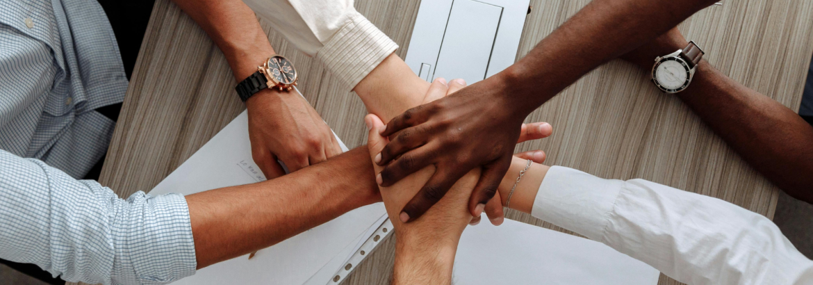 Multiple Hands All touching to represent teamwork