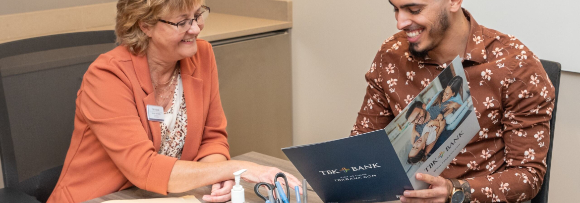 two people sitting at a desk talking to each other