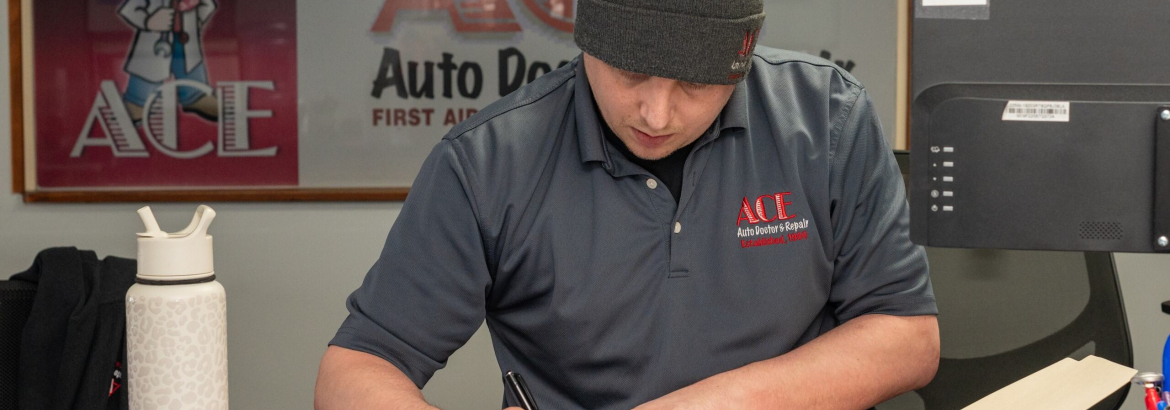 man in a hat writing on a piece of paper