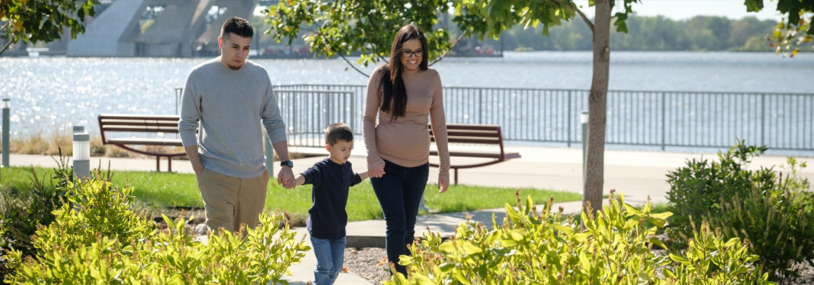 young family walking along the riverfront